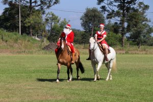 Papai e Mamãe Noel chegam a cavalo em escola de Chapecó
